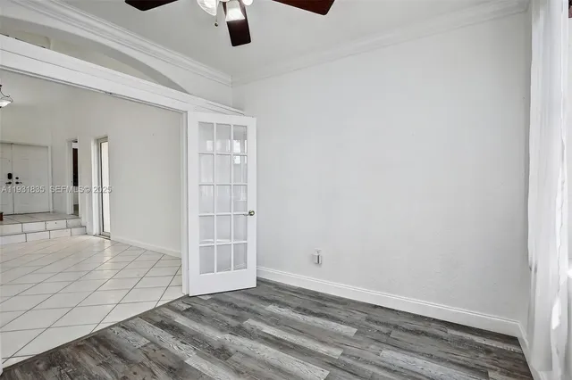 an empty room with ceiling fan and window