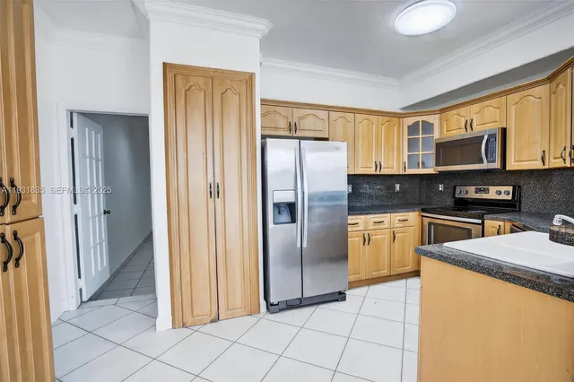 a kitchen with stainless steel appliances granite countertop a refrigerator and a stove top oven
