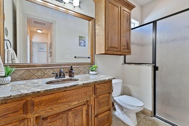 12901 Smokey Ranch Drive Fort Worth, TX 76052 - Photo 23 of 40 a bathroom with a granite countertop sink toilet and mirror