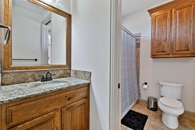 12901 Smokey Ranch Drive Fort Worth, TX 76052 - Photo 26 of 40 a bathroom with a granite countertop toilet sink and mirror