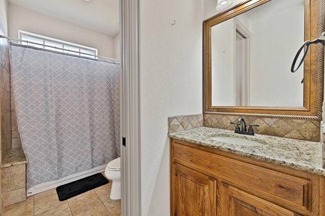 12901 Smokey Ranch Drive Fort Worth, TX 76052 - Photo 28 of 40 a bathroom with a granite countertop sink and a mirror