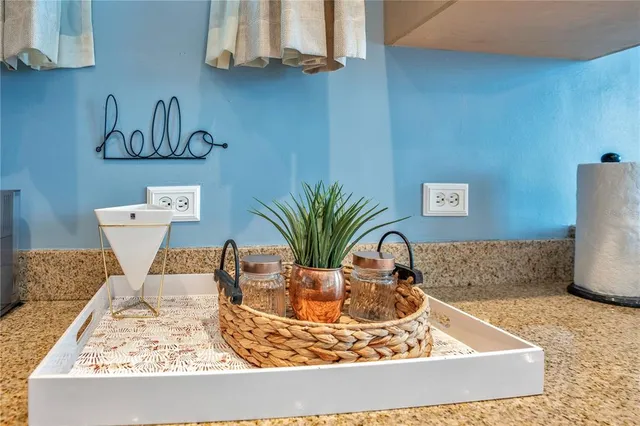 a kitchen with stainless steel appliances granite countertop wooden cabinets a sink a stove a dining table and chairs