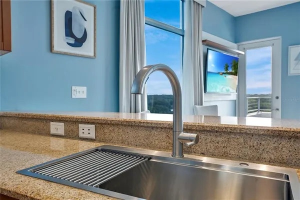 a kitchen with stainless steel appliances kitchen island granite countertop a refrigerator a stove a sink dishwasher and white cabinets with wooden floor