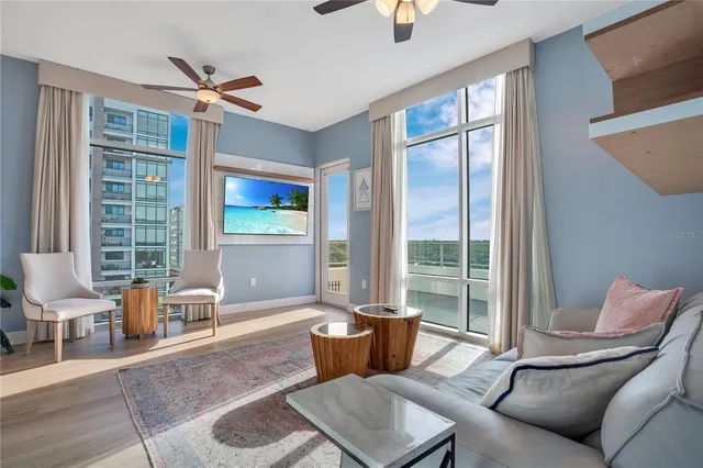 a living room with furniture kitchen view and a chandelier