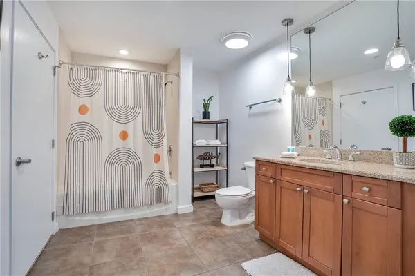 a dining hall with stainless steel appliances kitchen island granite countertop a table chairs and a glass door