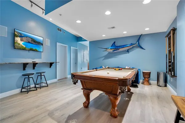 a living room with furniture pool table and a rug