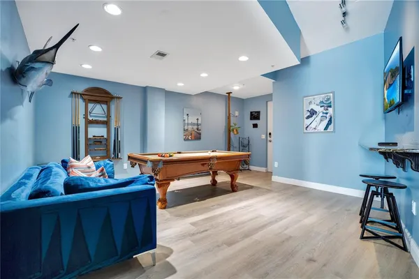 a kitchen with a refrigerator a stove and a dining table with wooden floor