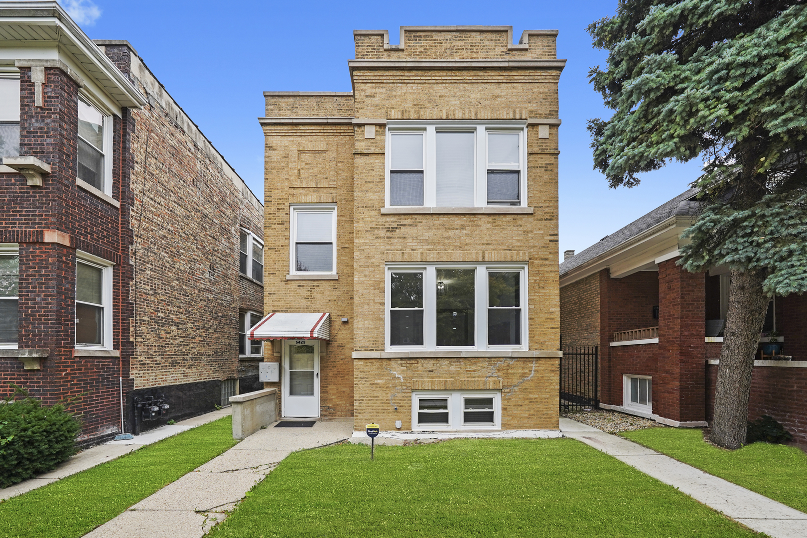 6423 South Maplewood Avenue, Unit 1 Chicago, IL 60629 - Photo 1 of 1 a large brick building with a big yard and more windows