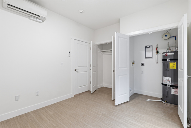 2085 North Main Street, Unit 409 Sunset, UT 84015 - Photo 6 of 17 Bedroom with secured water heater, light wood-style flooring, and a closet