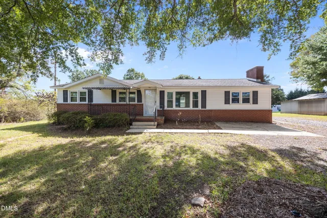 a front view of a house with yard and trees