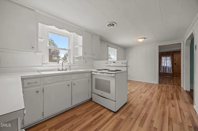 a kitchen with wooden floors and white cabinets