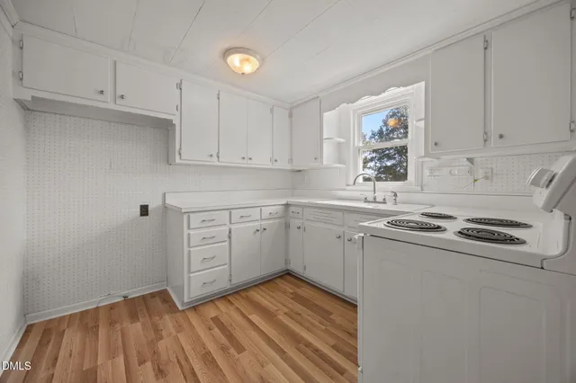 a kitchen with cabinets appliances a sink and a window