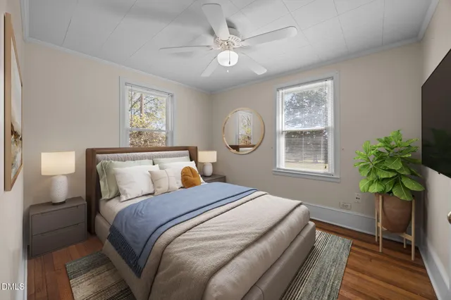 a bedroom with a bed and a potted plant on the dresser