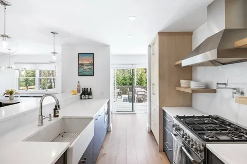 a kitchen with stainless steel appliances granite countertop a sink stove and refrigerator