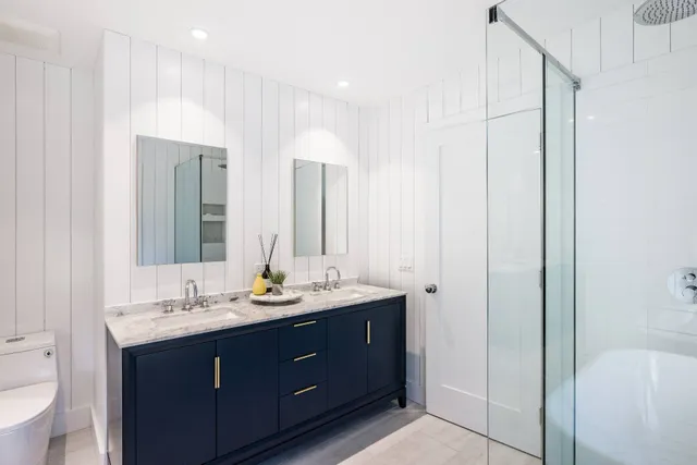 a bathroom with double vanity and a mirror
