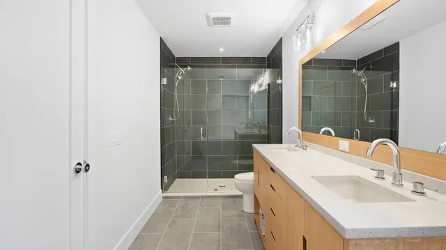 a bathroom with a sink mirror and shower