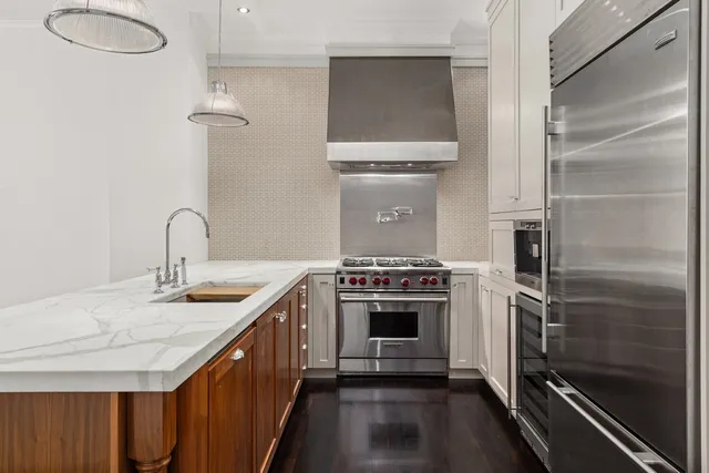a kitchen with stainless steel appliances a white stove top oven and a wooden floor