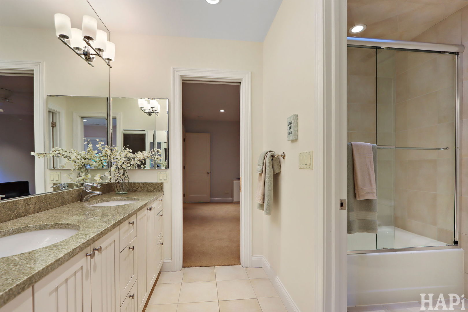 1425 Lee Road Northbrook, IL 60062 - Photo 32 of 53 a bathroom with a granite countertop sink a mirror and a shower