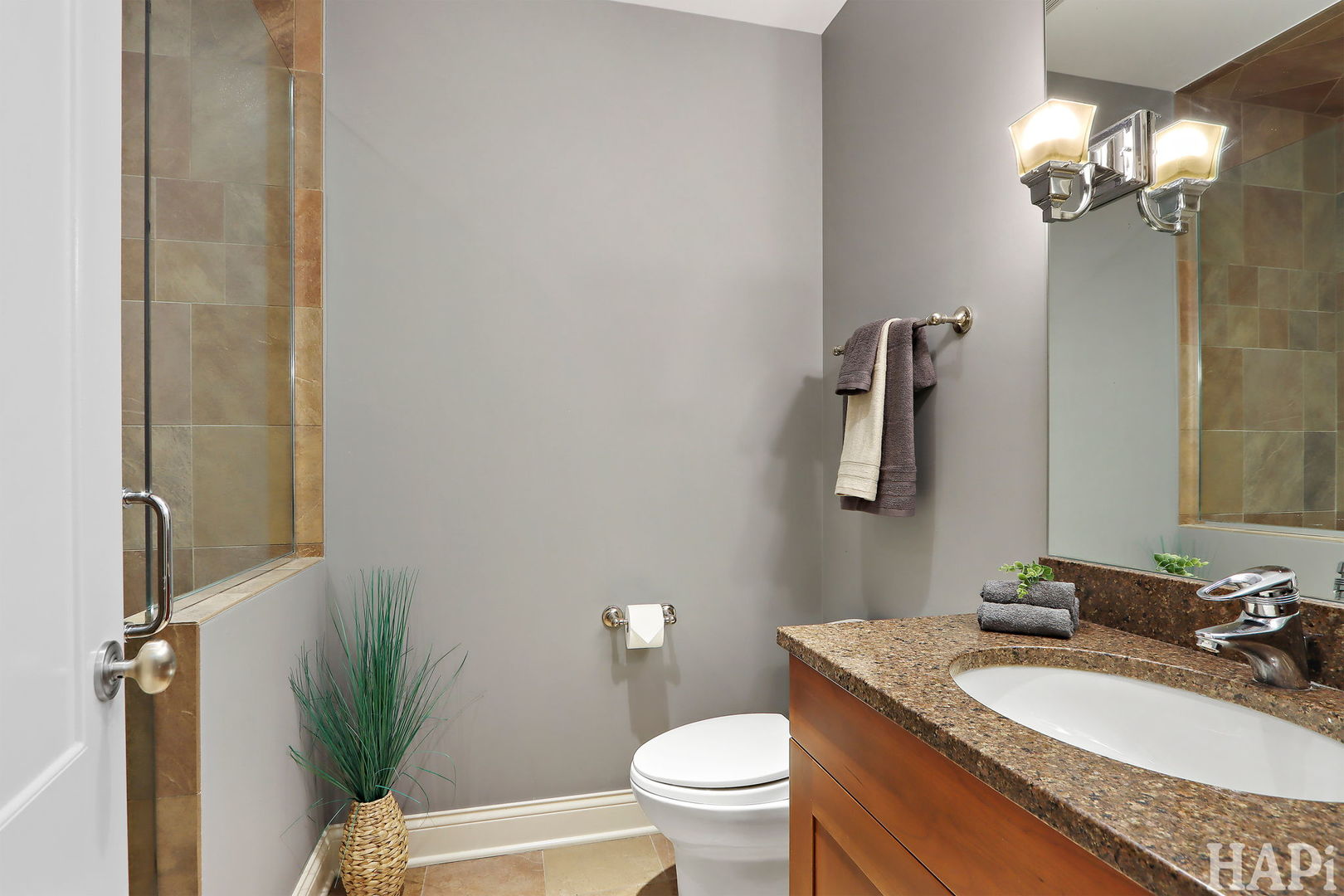 1425 Lee Road Northbrook, IL 60062 - Photo 36 of 53 a bathroom with a granite countertop sink a toilet a mirror and shower
