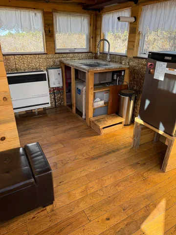 a living room with stainless steel appliances kitchen island granite countertop furniture and a fireplace