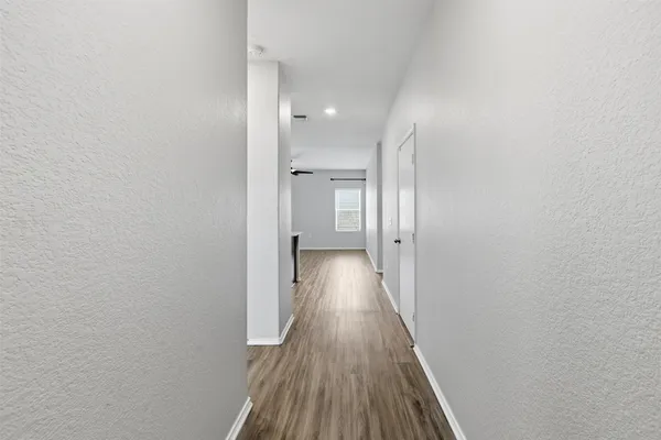 a view of a hallway with wooden floor