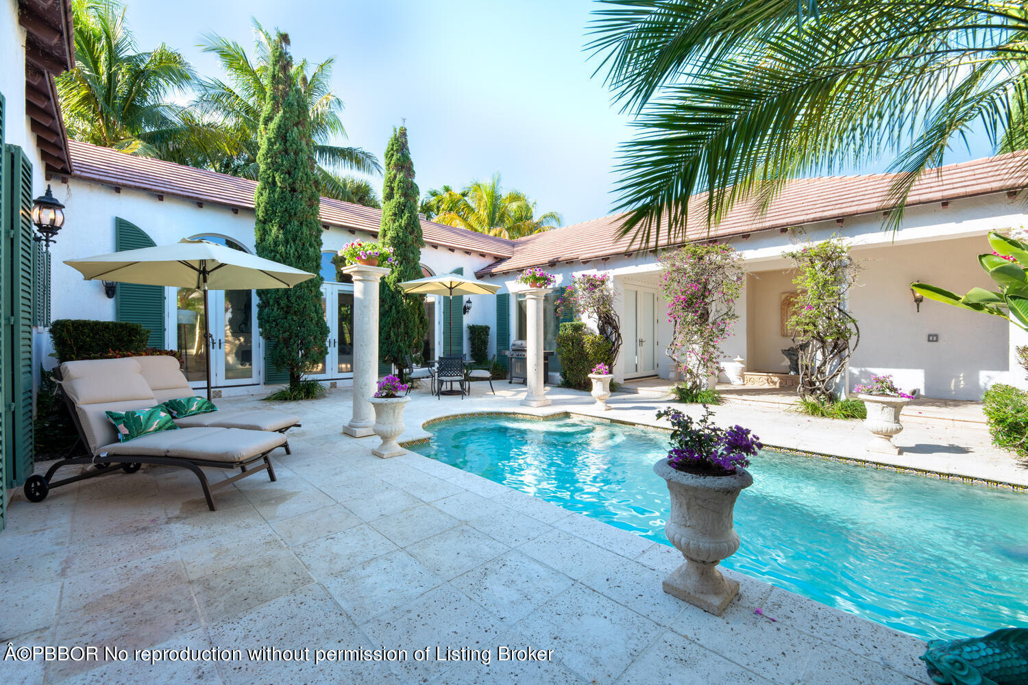 2258 Ibis Isle Road East Palm Beach, FL 33480 - Photo 19 of 31 a view of a patio with dining table and chairs under an umbrella