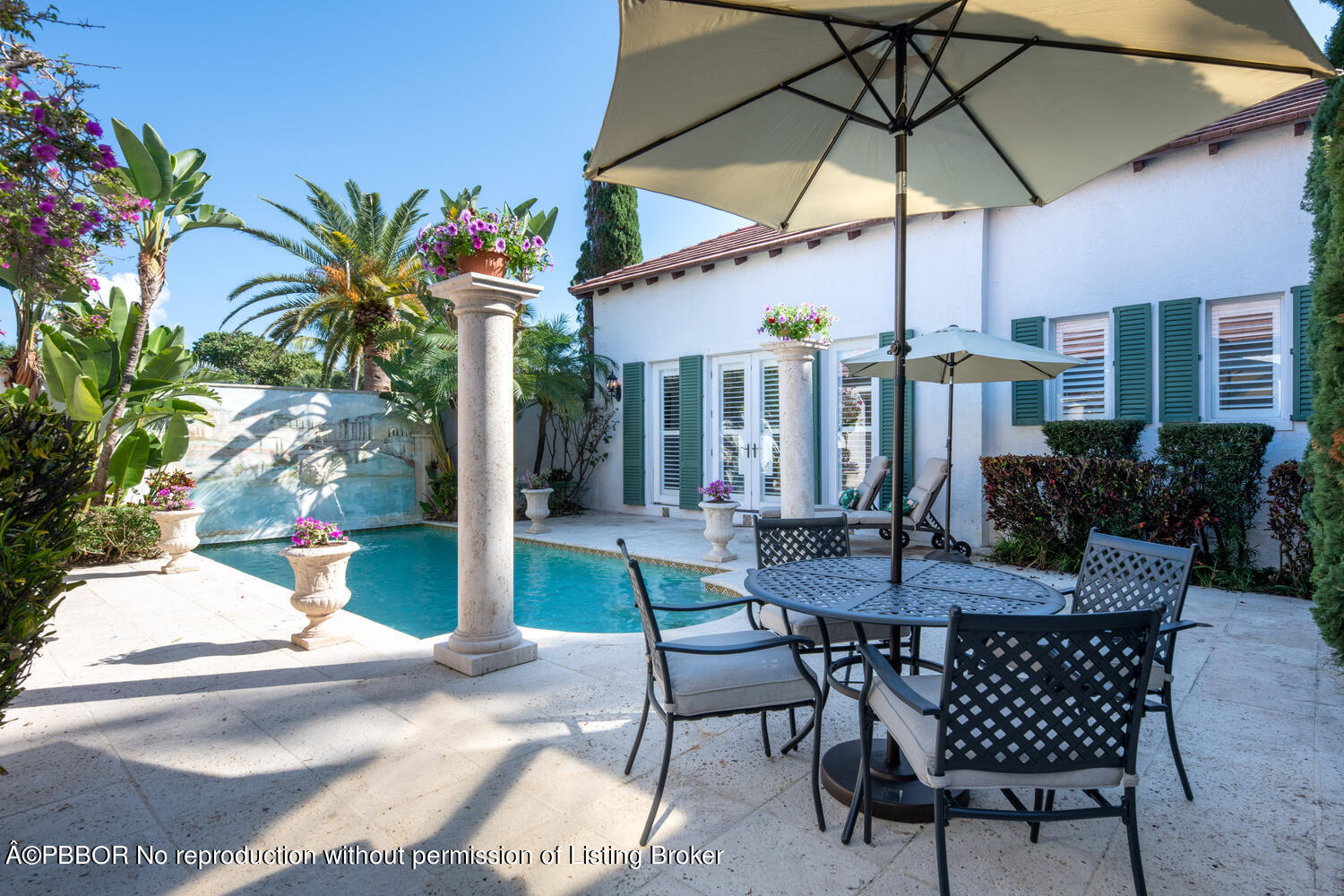 2258 Ibis Isle Road East Palm Beach, FL 33480 - Photo 20 of 31 a view of a patio with a table and chairs under an umbrella