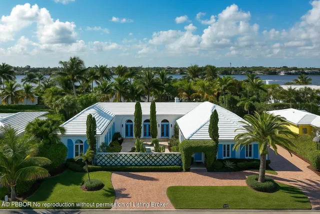 a view of a house with a yard and potted plants