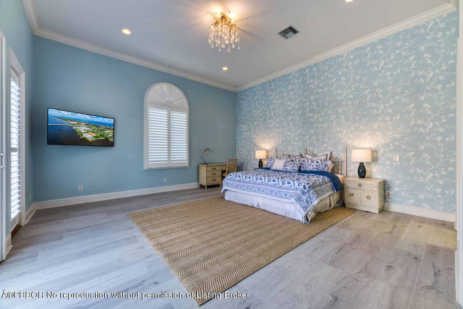 2258 Ibis Isle Road East Palm Beach, FL 33480 - Photo 22 of 31 a bedroom with a large bed and a chandelier