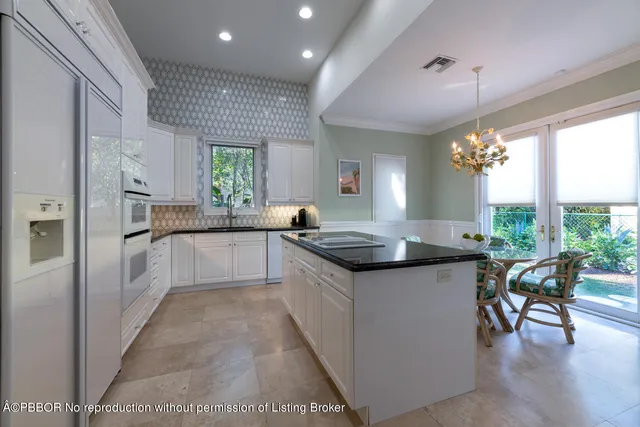 a kitchen with stainless steel appliances granite countertop a kitchen island a stove a dining table and chairs