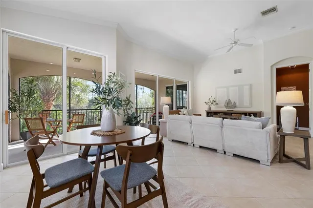 a kitchen with stainless steel appliances granite countertop a stove top oven a sink dishwasher a dining table and chairs with wooden floor