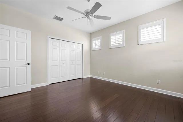 a view of a white house with a yard and a large tree