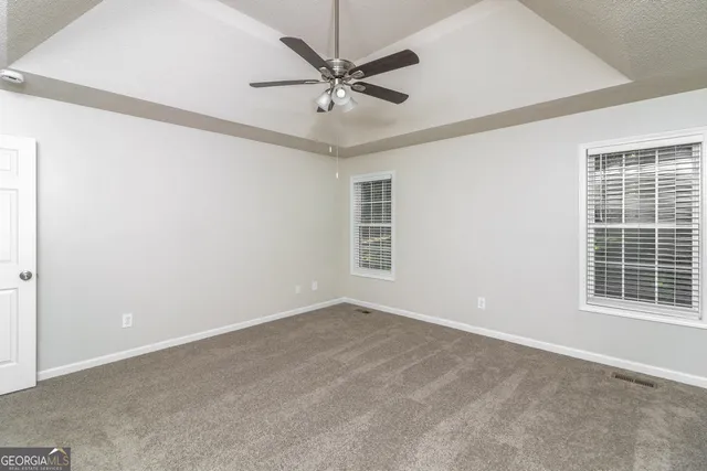 a view of a livingroom with a ceiling fan and window