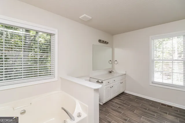 a bathroom with a tub sink and a window