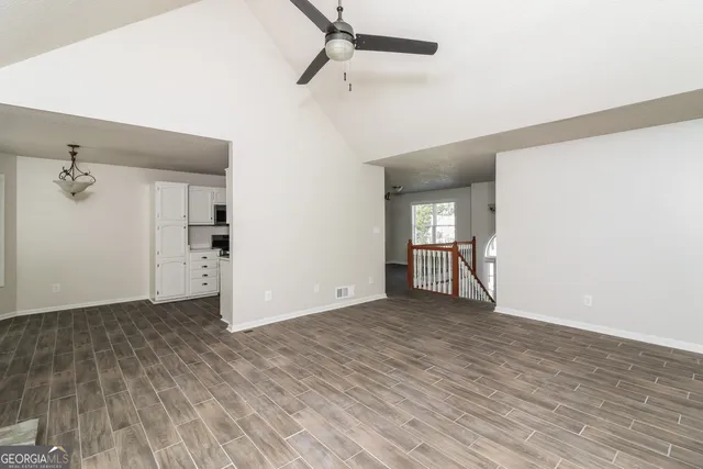 a view of empty room with wooden floor