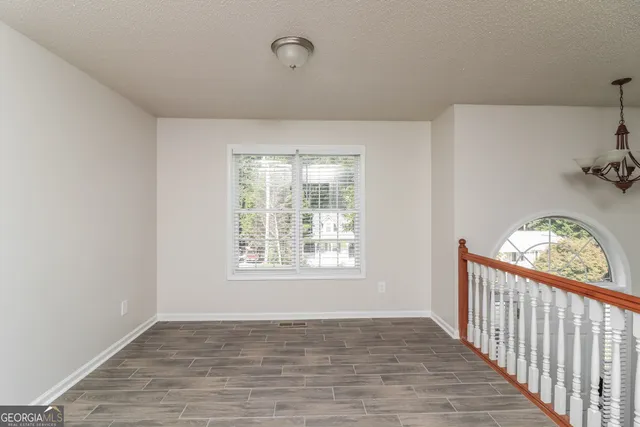 a view of a room with wooden floor fan and windows