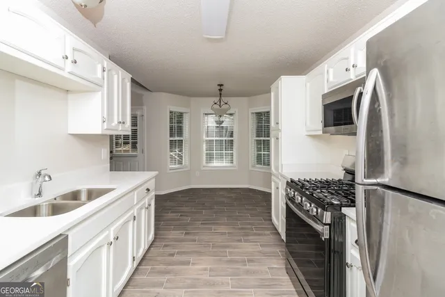 a kitchen with stainless steel appliances a sink stove and refrigerator