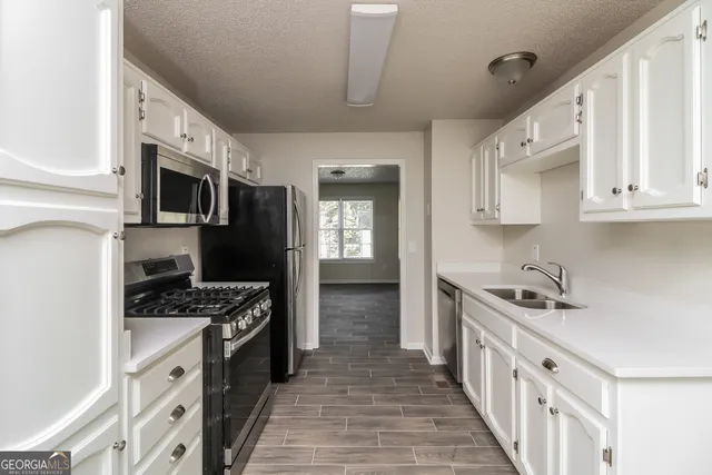 a kitchen with stainless steel appliances a stove sink microwave and cabinets