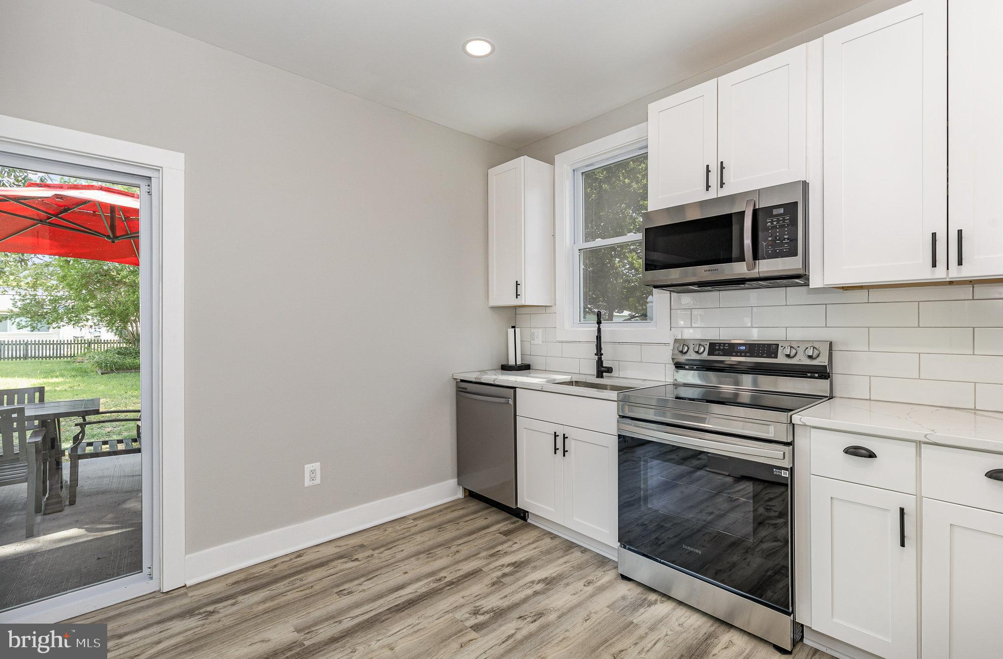 530 Monroe Bay Avenue Colonial Beach, VA 22443 - Photo 8 of 33 a kitchen with stainless steel appliances granite countertop a stove top oven a sink and white cabinets