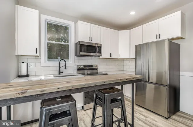 a kitchen with appliances a sink cabinets and a window