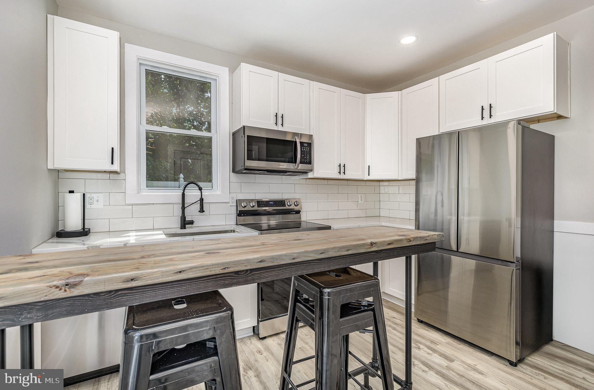 530 Monroe Bay Avenue Colonial Beach, VA 22443 - Photo 9 of 33 a kitchen with appliances a sink cabinets and a window
