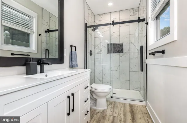 a bathroom with a shower toilet sink and mirror