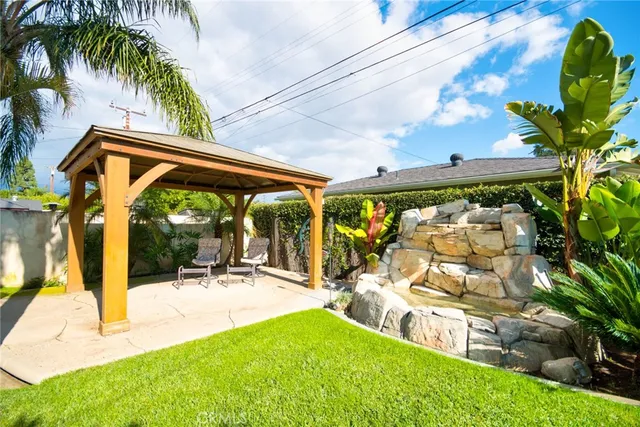 a view of a house with a yard and palm trees