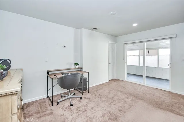 a bedroom with a bed and a large mirror on the dresser