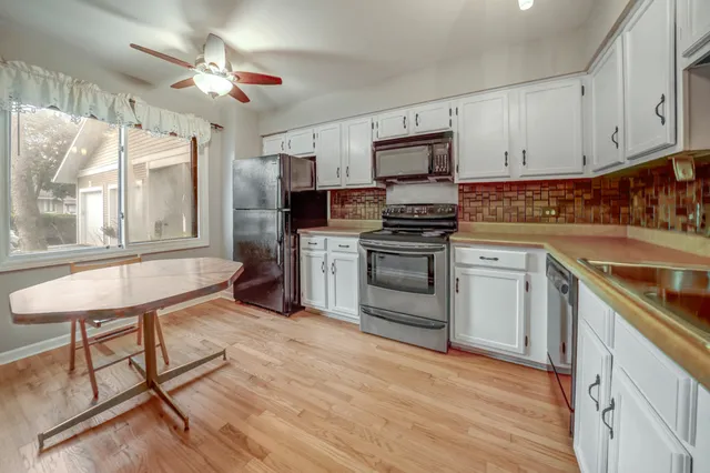 a kitchen with stainless steel appliances granite countertop a stove cabinets and wooden floor