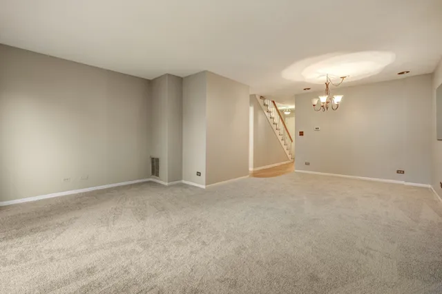 an empty room with closet and a chandelier fan