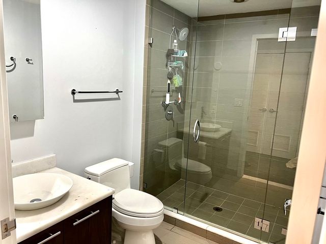 a bathroom with a shower a toilet and a sink