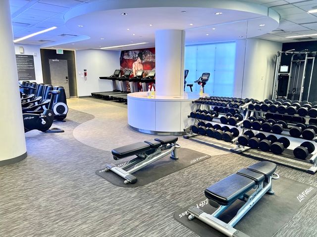 a room with gym equipment and a flat screen tv