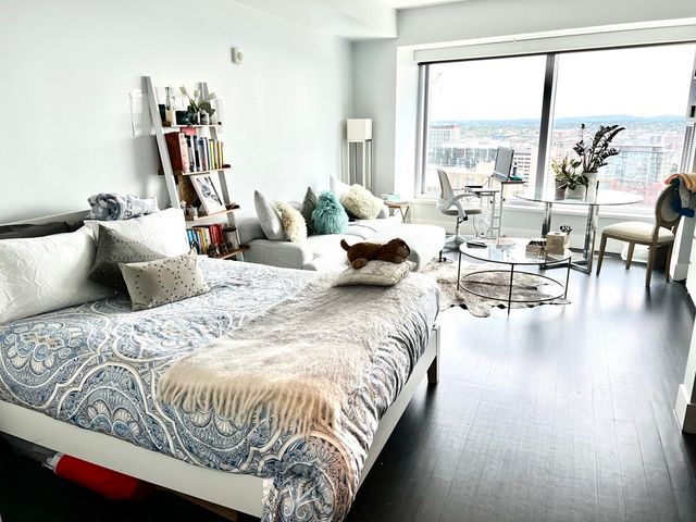 a bedroom with bed and large windows
