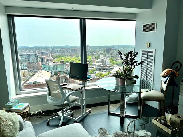 a view of a workspace with furniture and a window